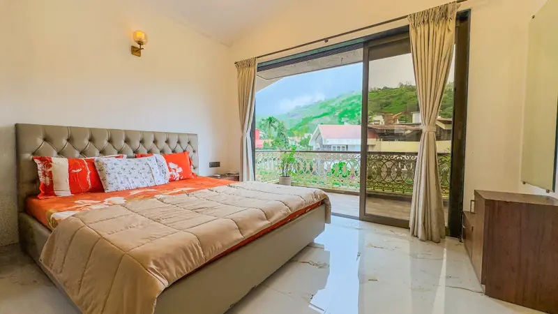 Bedroom with sliding doors onto a balcony facing the hills